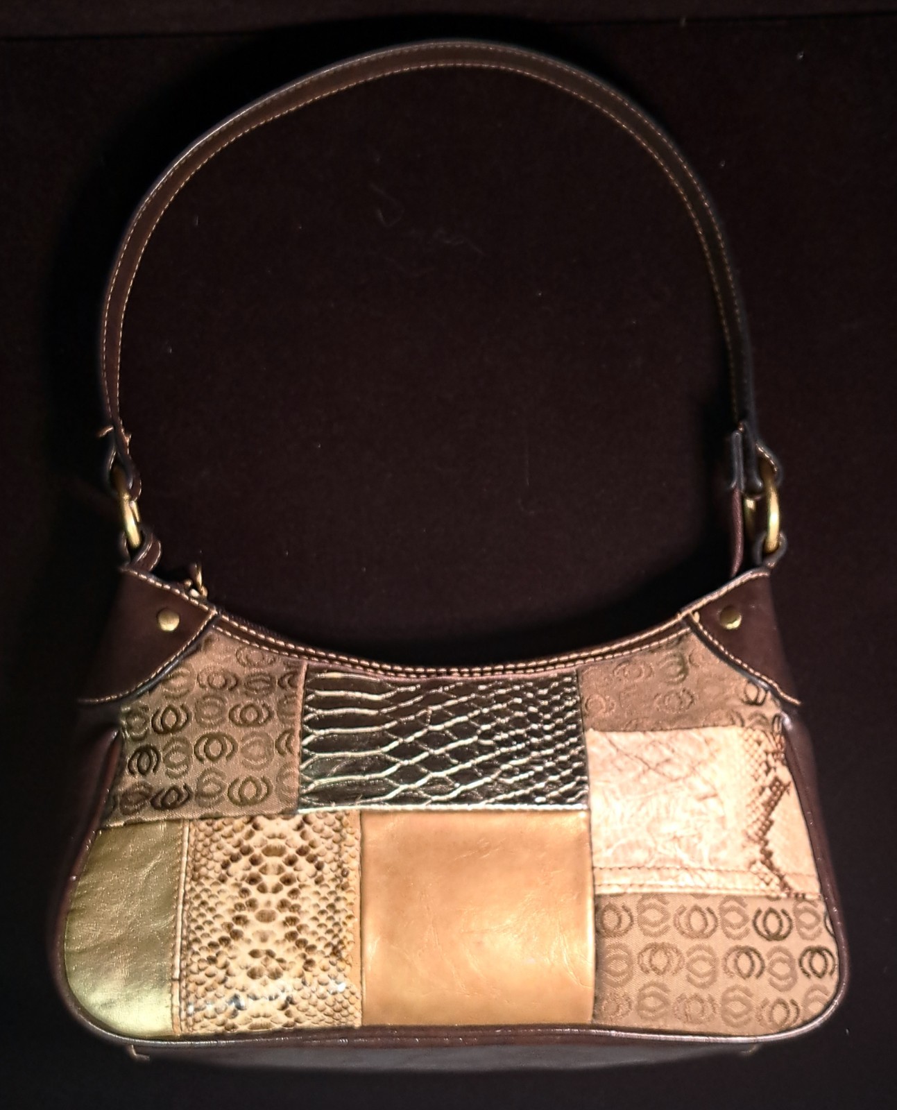 a small, patchwork-style shoulder handbag featuring various textures and colors