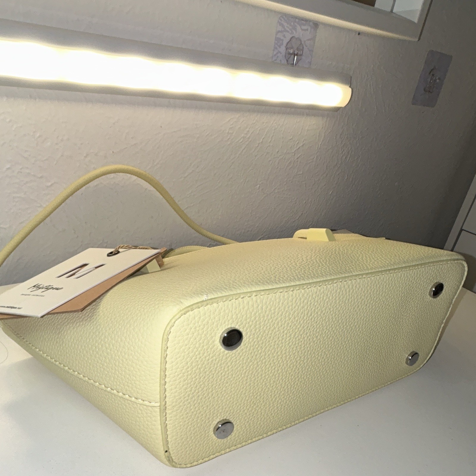 Brand new purse with original tag attached. Cute light yellow/cream tote bag.