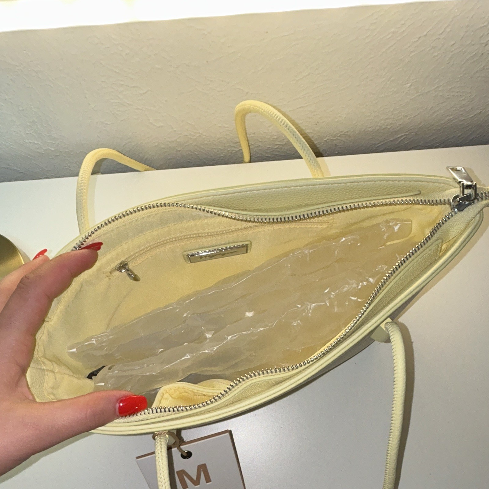 Brand new purse with original tag attached. Cute light yellow/cream tote bag.