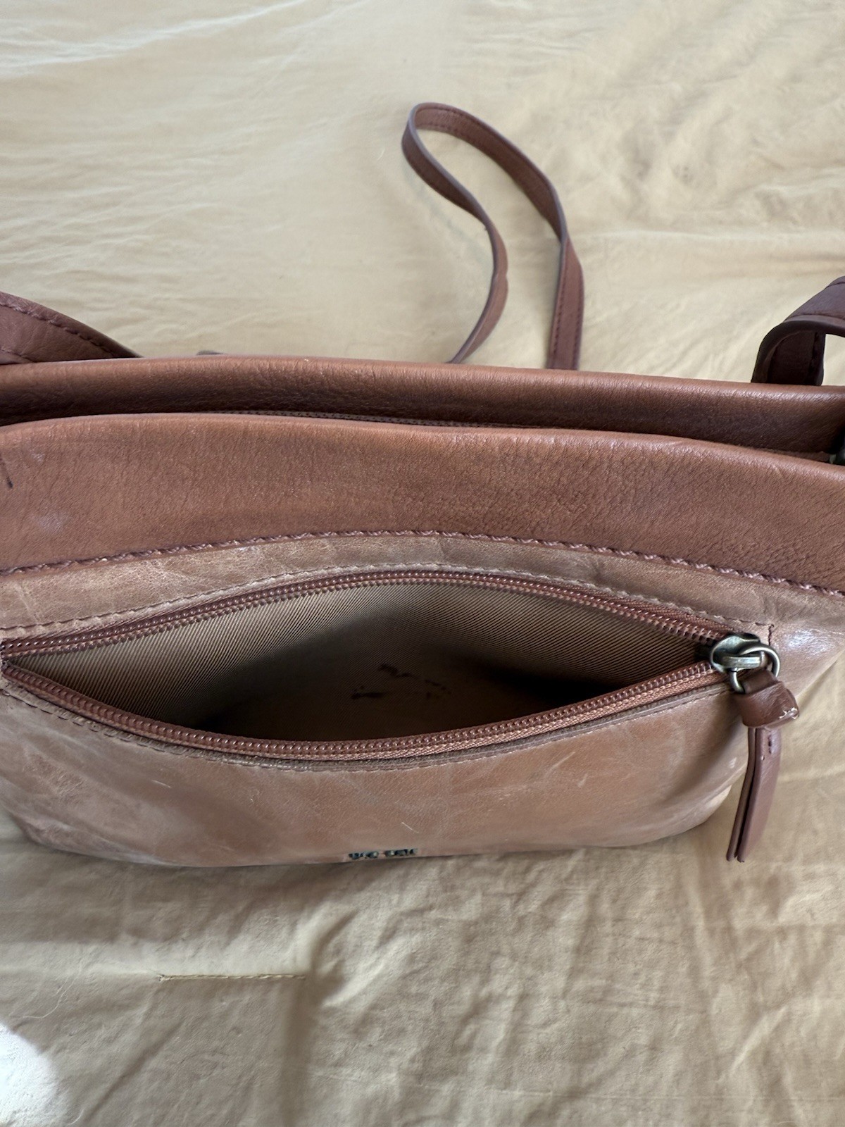 The Sak Brown Floral Crossbody Bag. This purse has been well loved.