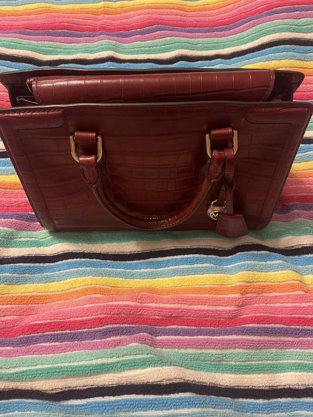 This red Michael Kors Zoe satchel is crafted from crocodile-embossed leather