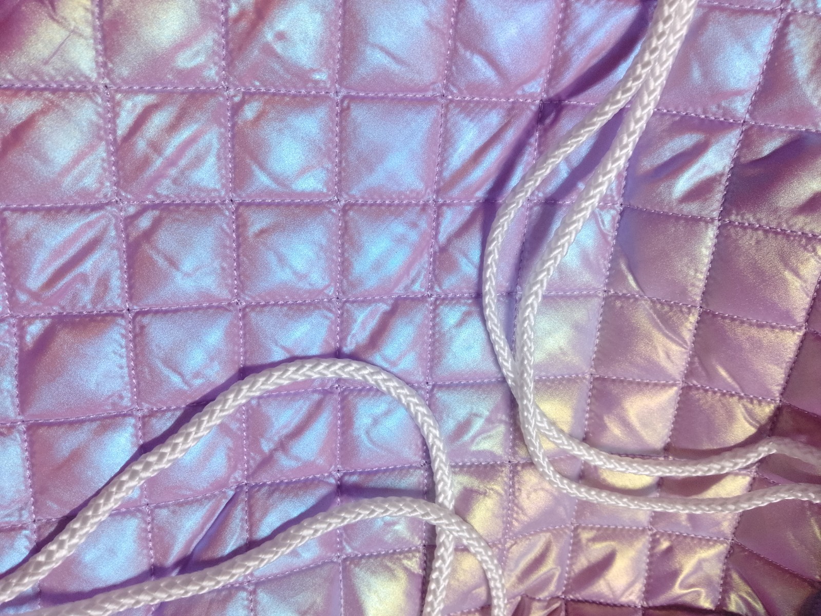 a purple quilted drawstring bag with an iridescent design and white drawstring