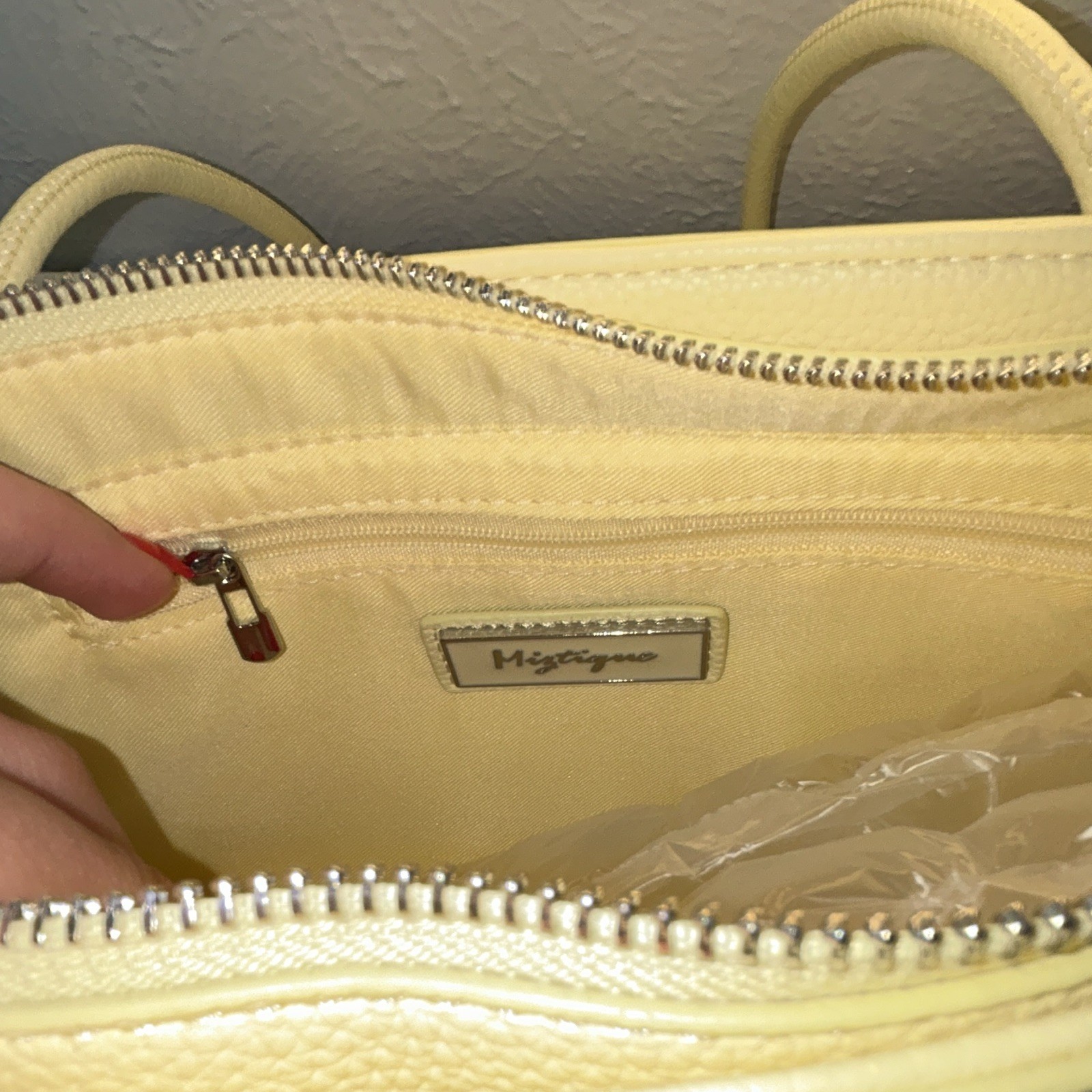 Brand new purse with original tag attached. Cute light yellow/cream tote bag.