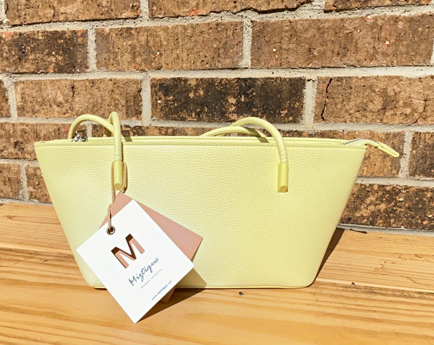 Brand new purse with original tag attached. Cute light yellow/cream tote bag.