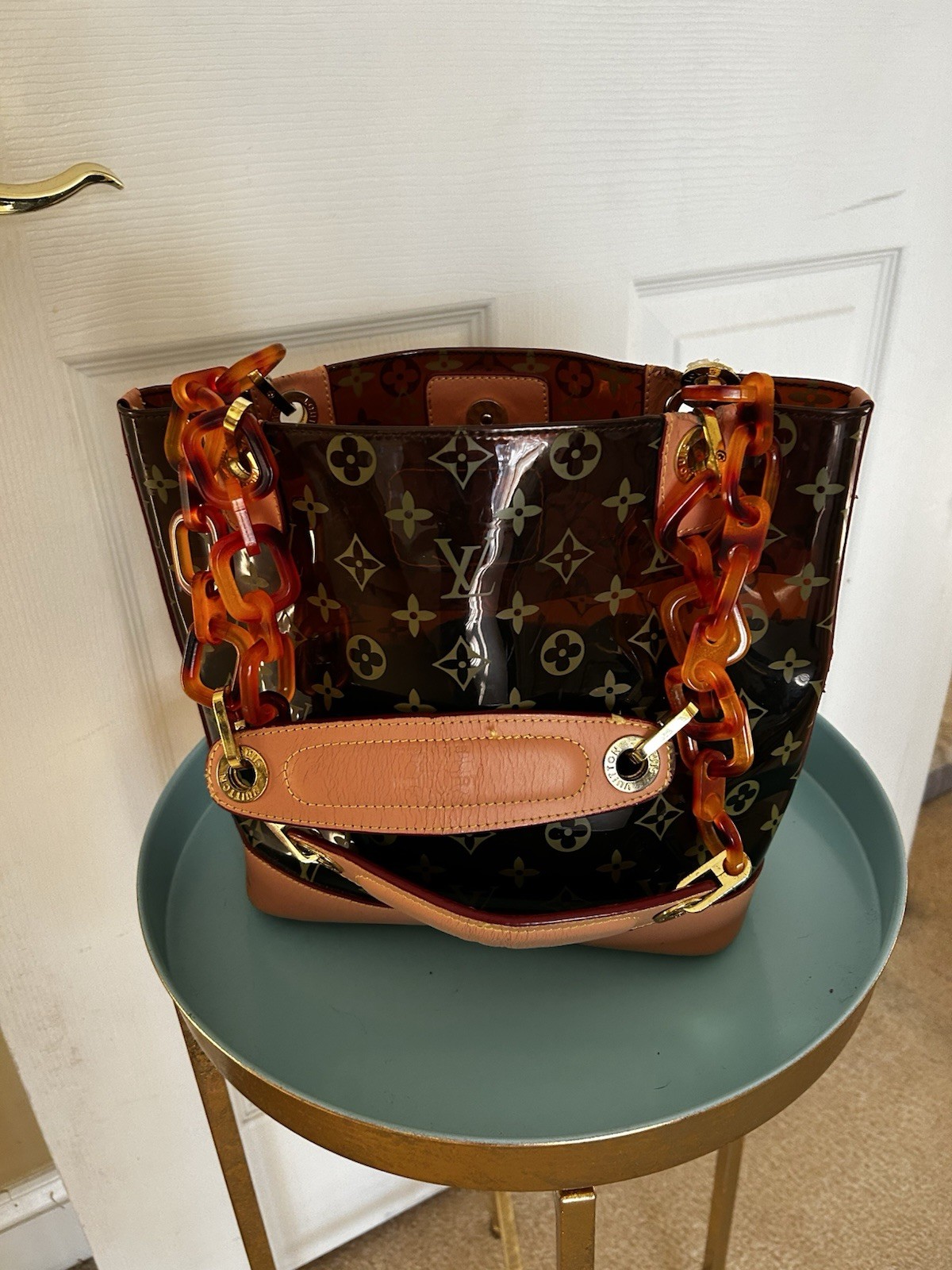 Purse vinyl exterior,amber-colored resin chain straps, and gold-tone hardware