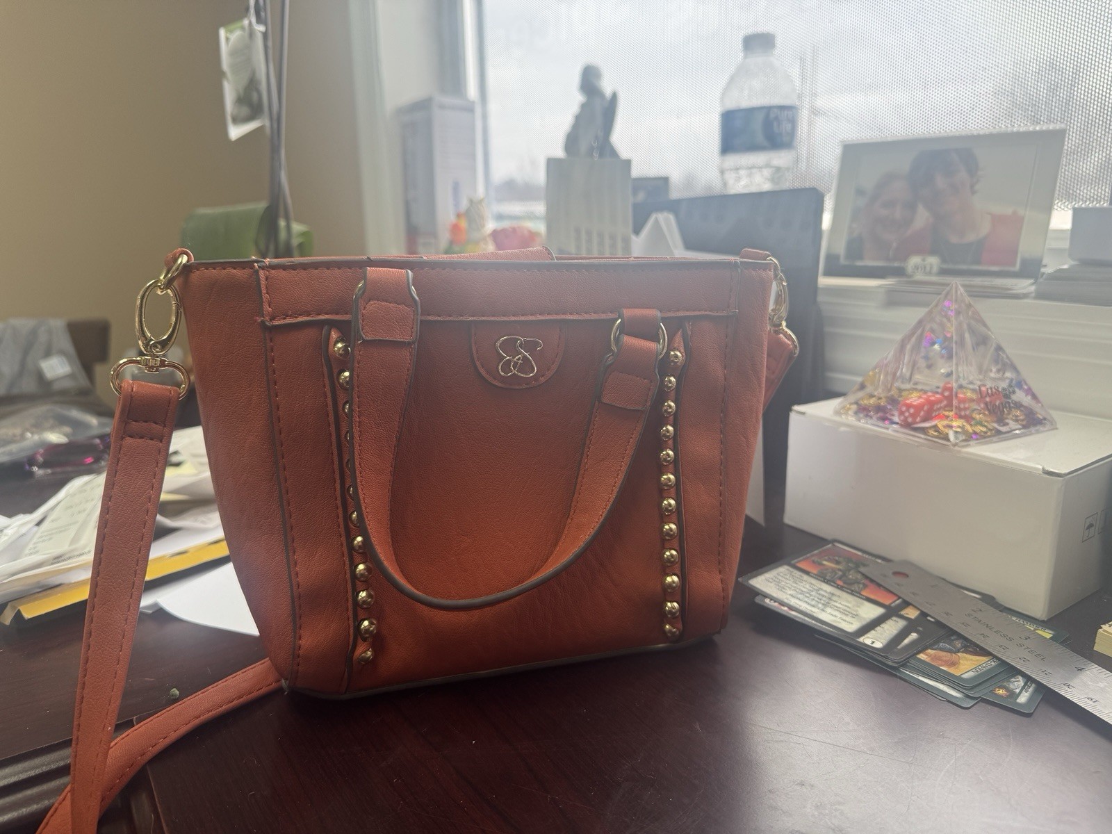 This is a Jessica Simpson orange crossbody bag, possibly the “Sadie” mode