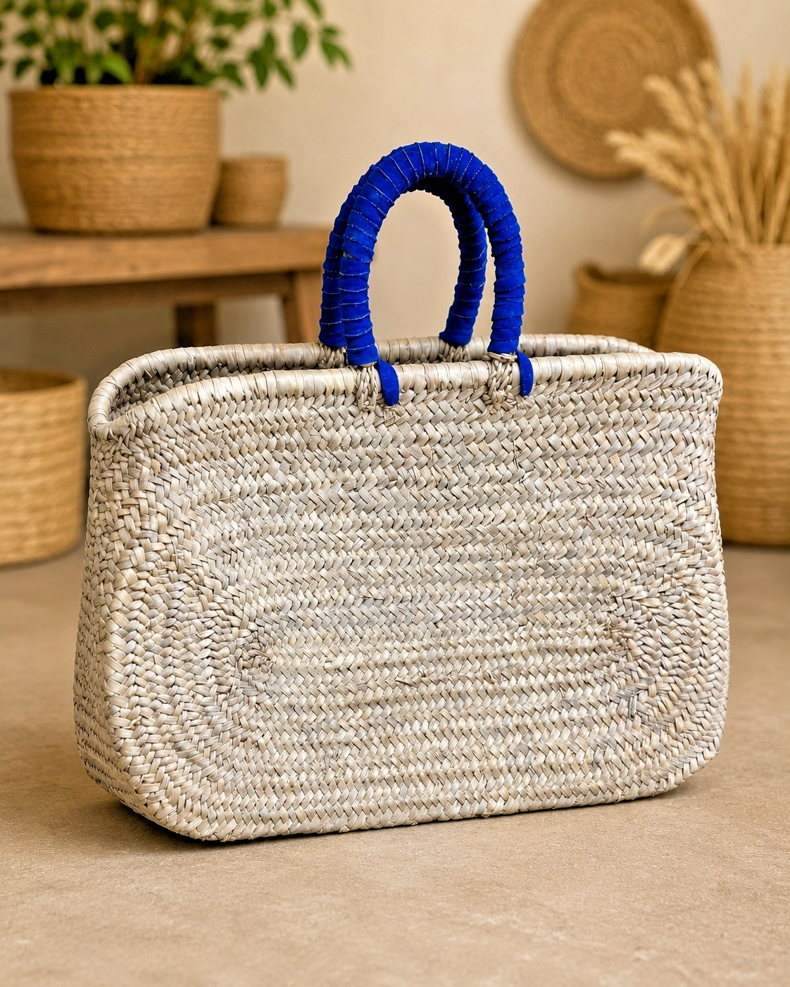 Handwoven straw shopping bag with blue handles, bohemian beach bag