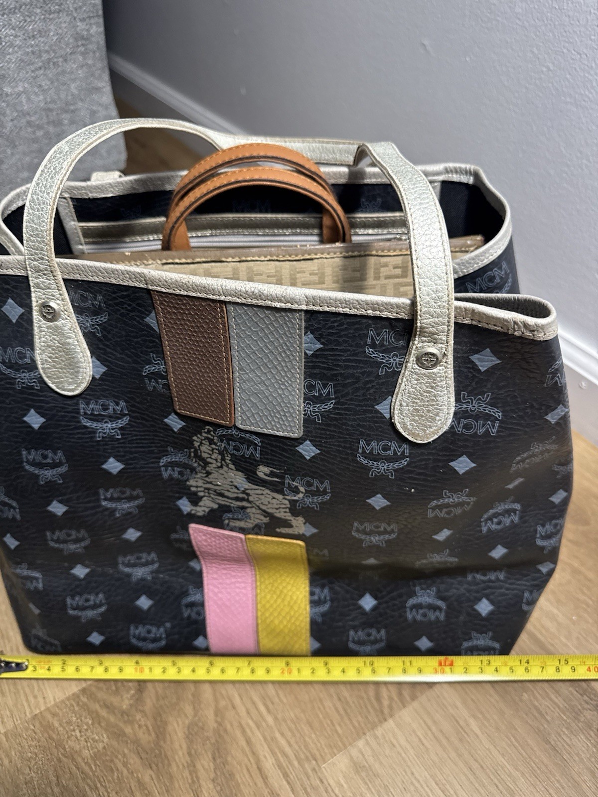 MCM black & gray tote bag with repeating white MCM logo and diamond pattern