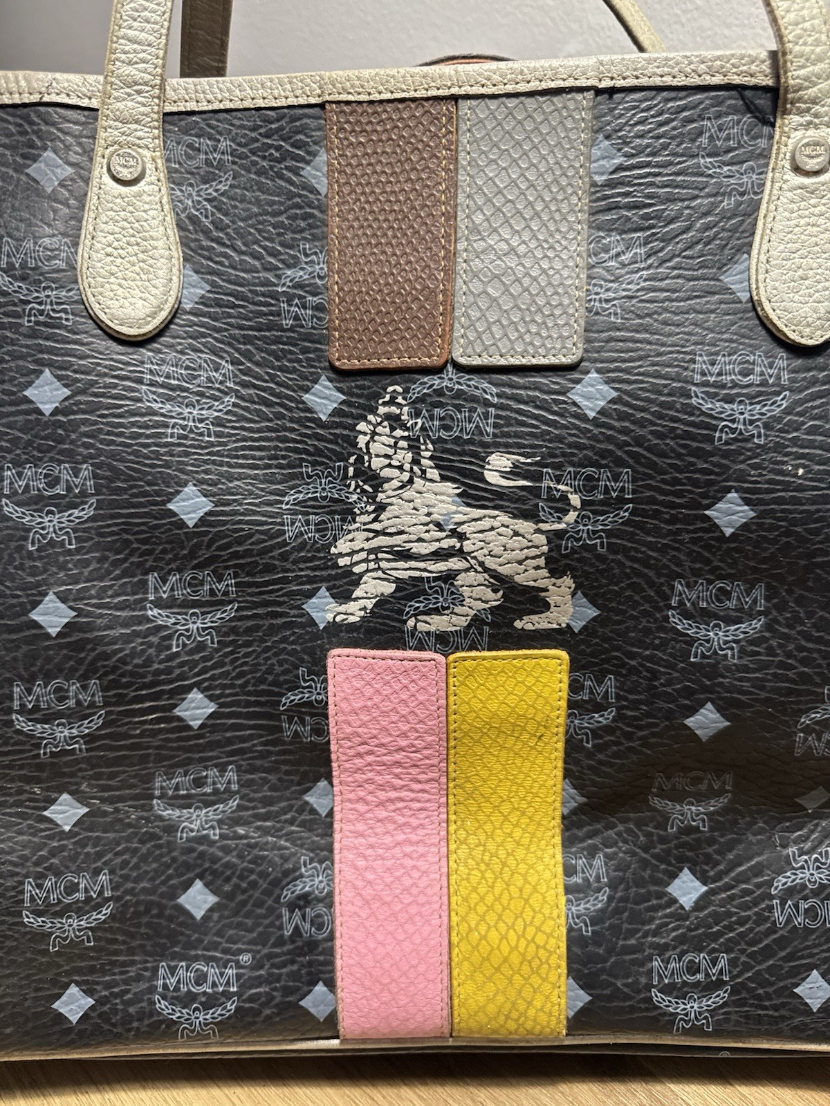 MCM black & gray tote bag with repeating white MCM logo and diamond pattern