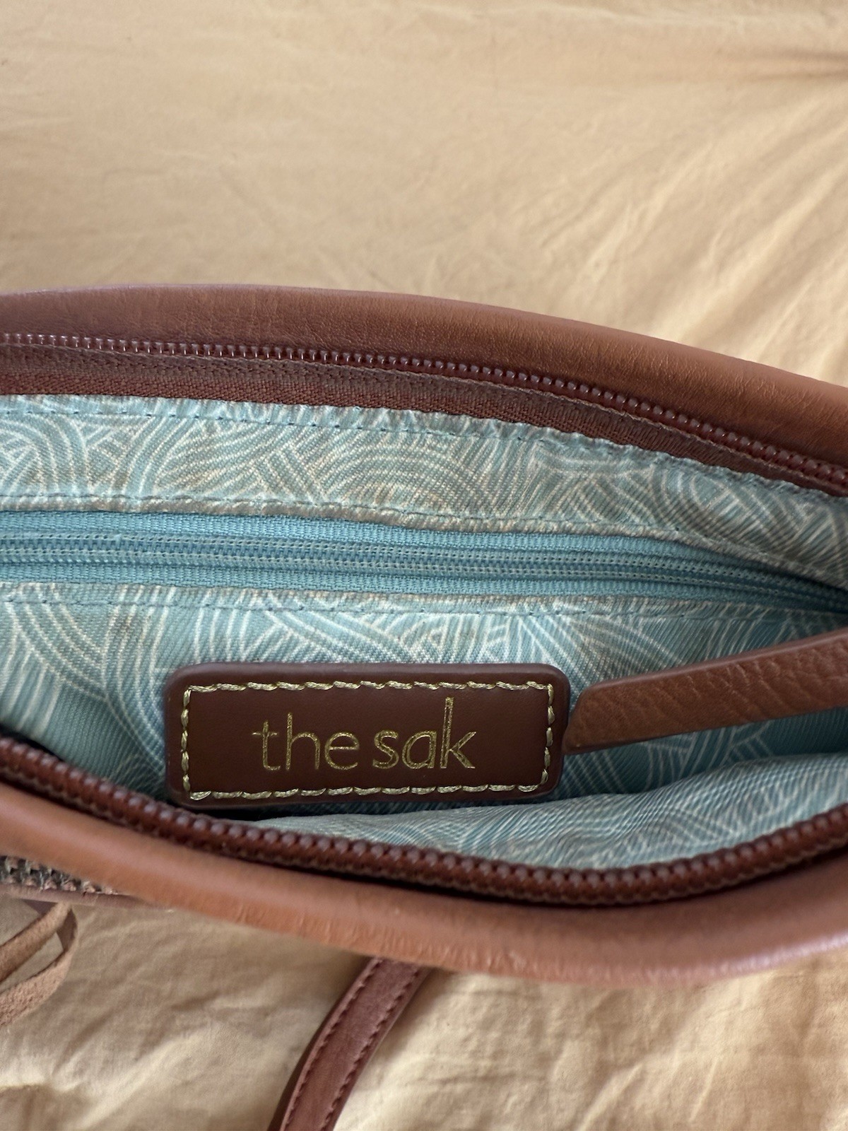 The Sak Brown Floral Crossbody Bag. This purse has been well loved.