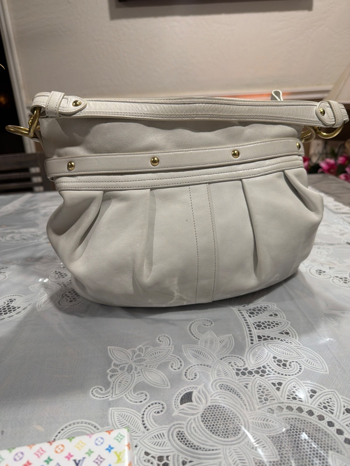 Coach Hampton hobo bag features distinctive pleated styling and decorative gold-