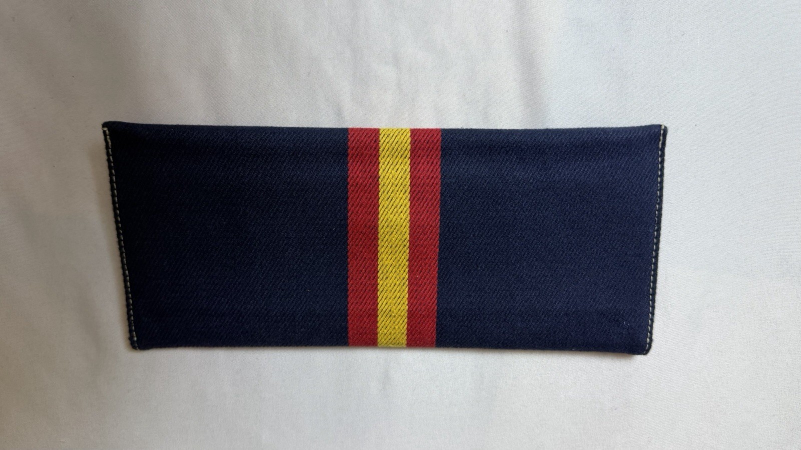 Blue Canvas Clutch With Silver Hardware On Front, Red And Yellow Stripes